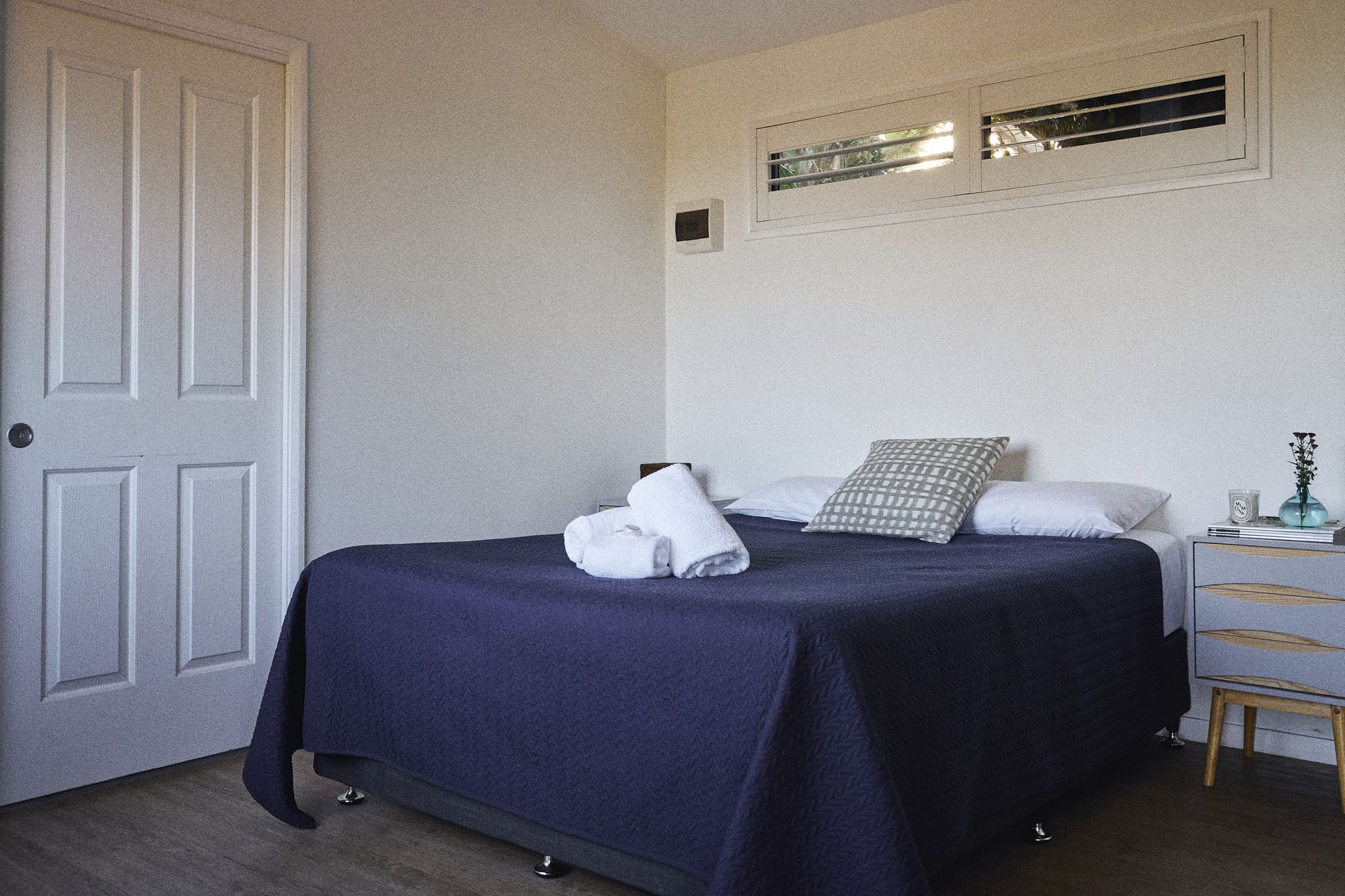 Queen bed next to door in Brooman Cabin.
