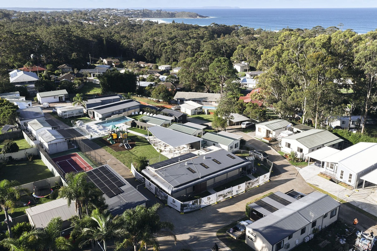 Aerial view of The Mook Mollymook, featuring holiday cabins and coastal surroundings.