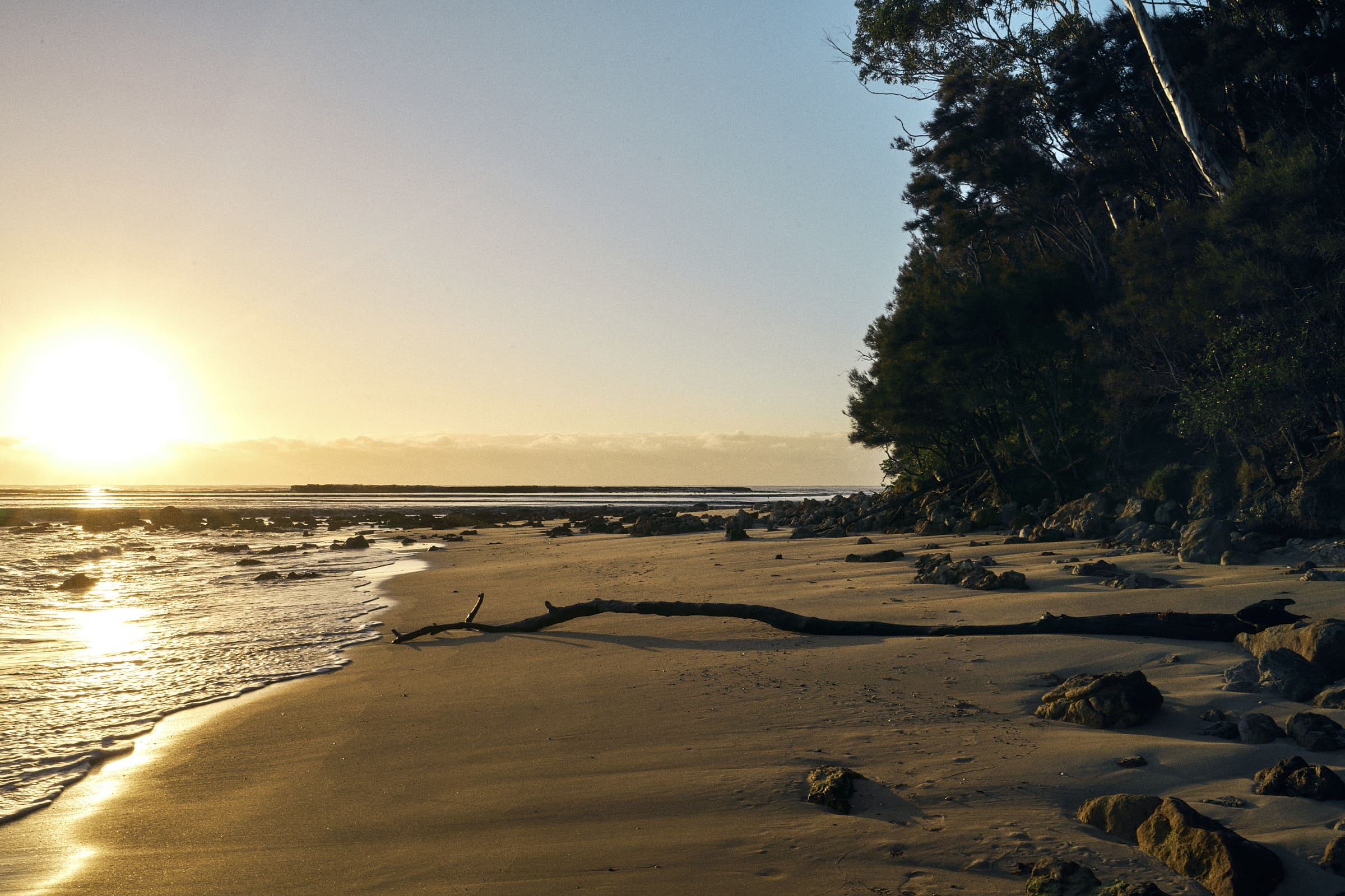 Sunset over Mollymook Beach with colourful skies and bright sun.