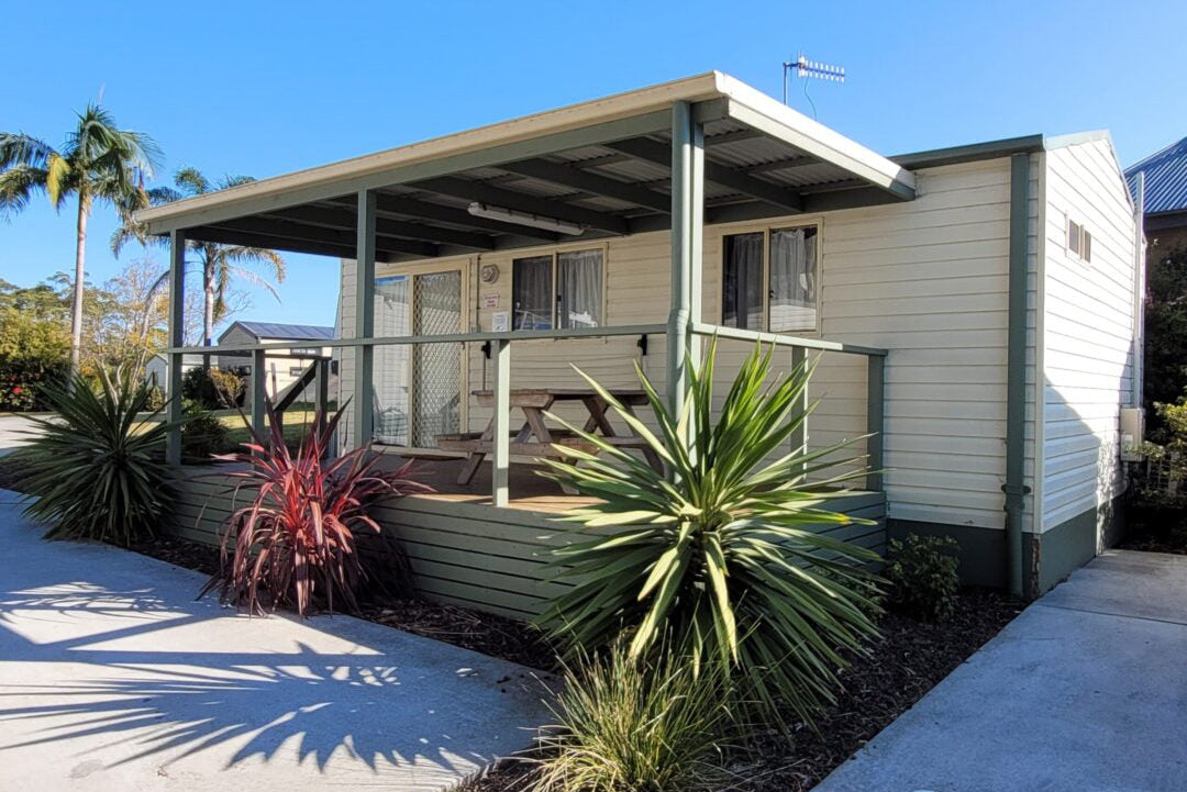Yerriyong C Cabin exterior with covered outdoor seating.