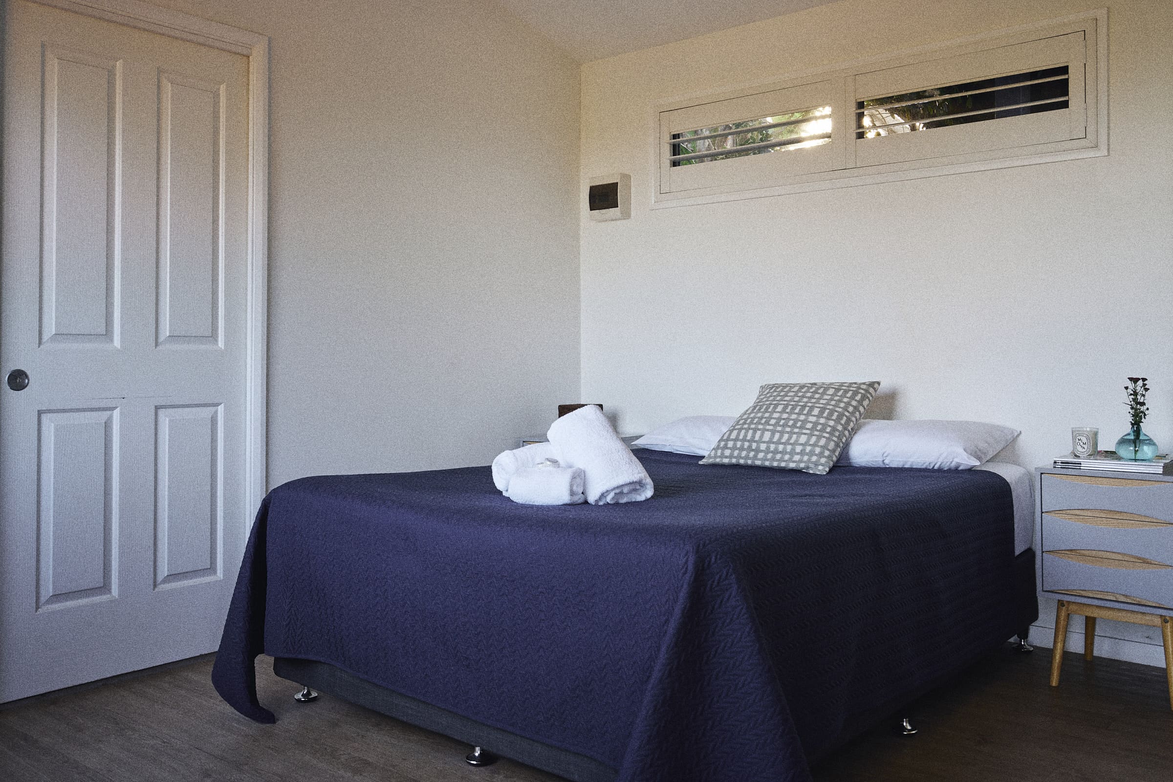 Queen bed next to door in Brooman Cabin.