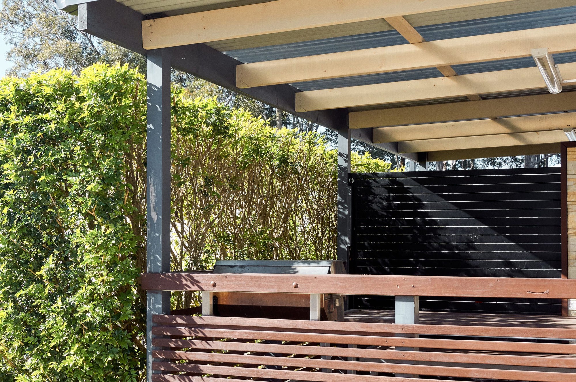 Covered deck with outdoor seating at Jerrawangala Cabin. 